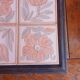 Ceramic tile trivet with floral patterns in pastel tones.