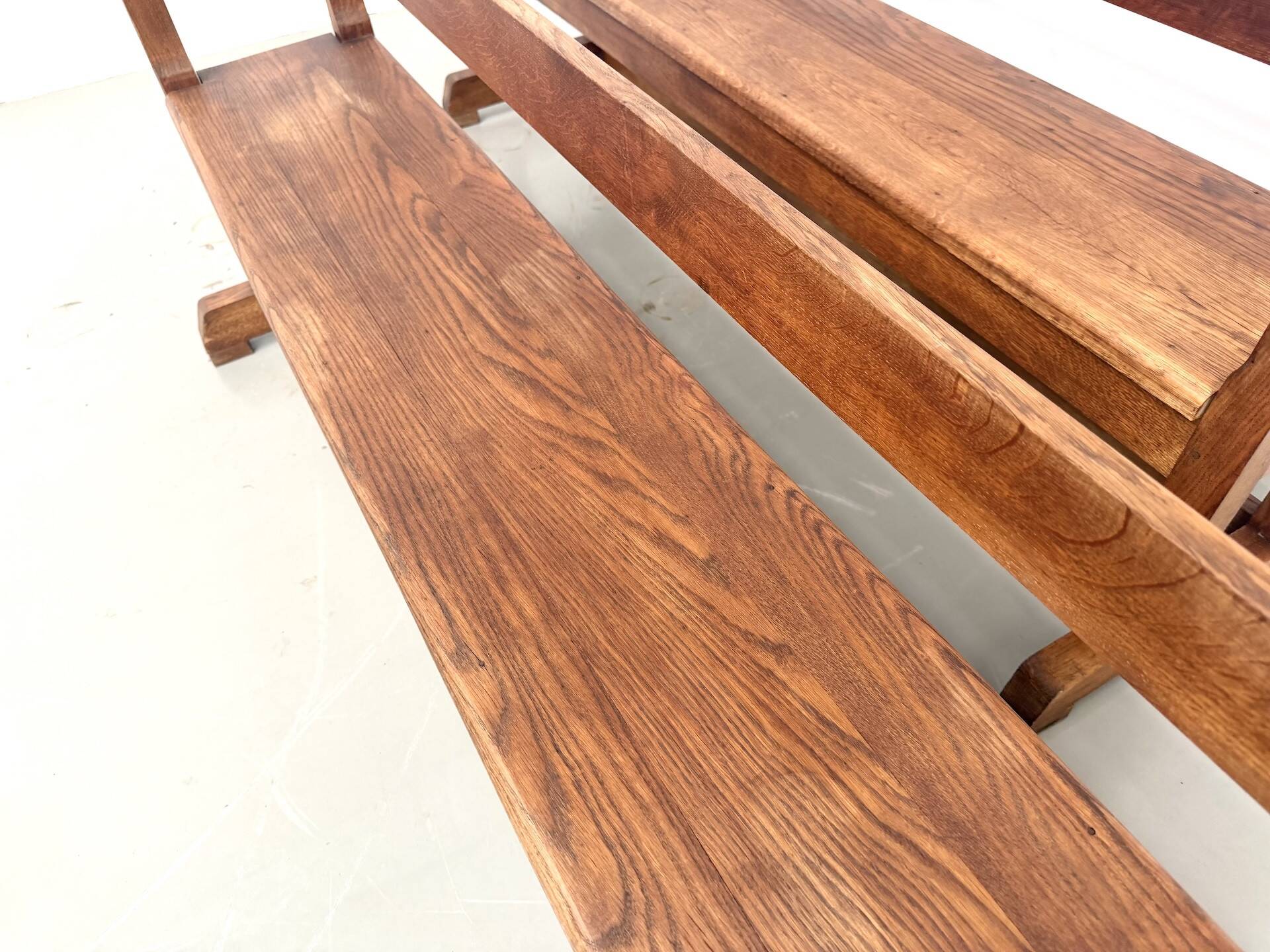 Pair of communal benches in solid oak, 1950s.