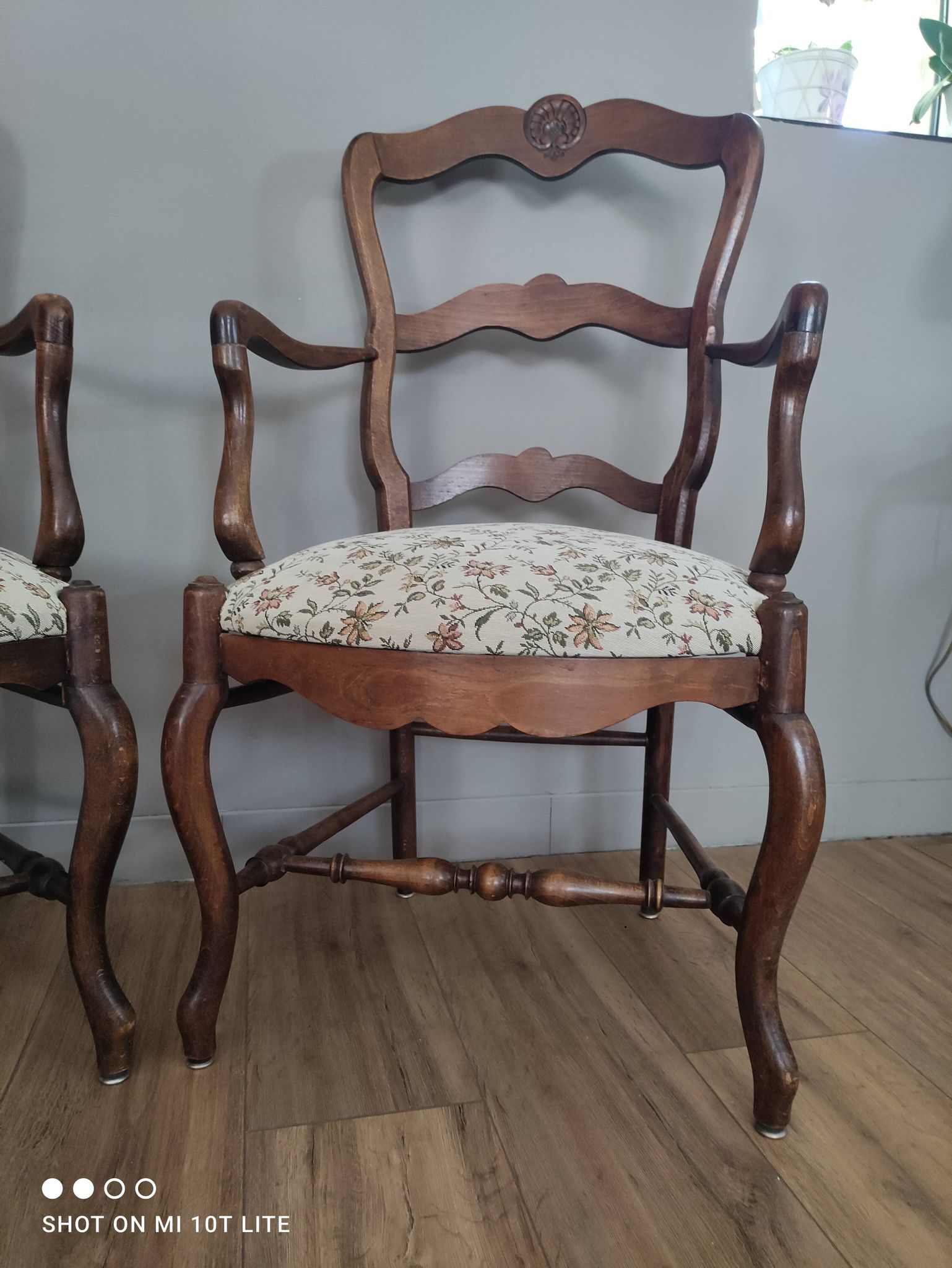 Pair of Provençal armchairs in brown wood and floral fabric.