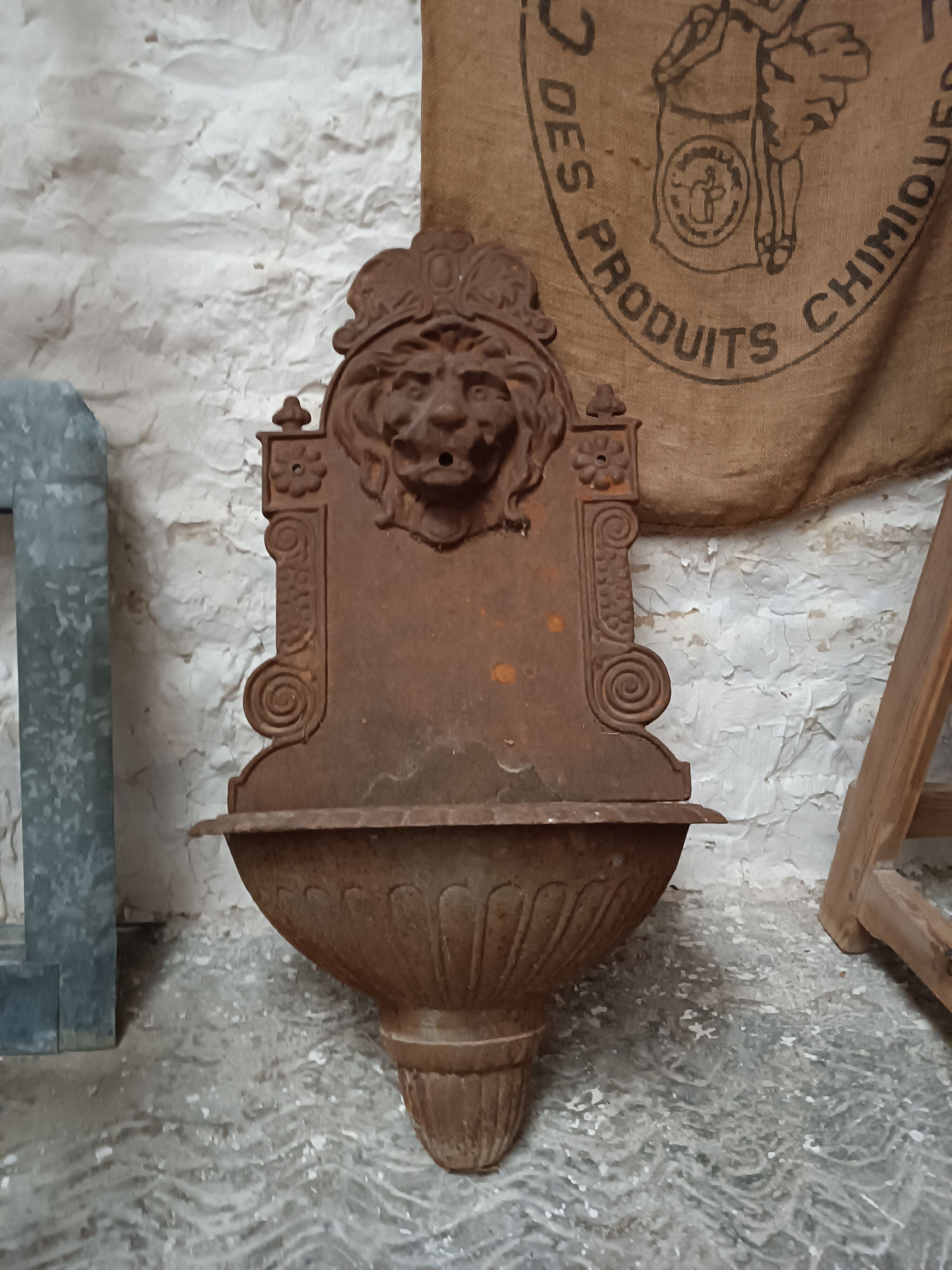 Old cast iron wall fountain with lion's head