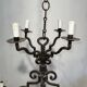 Two-tiered wrought iron chandelier with eight light arms in Gothic style.