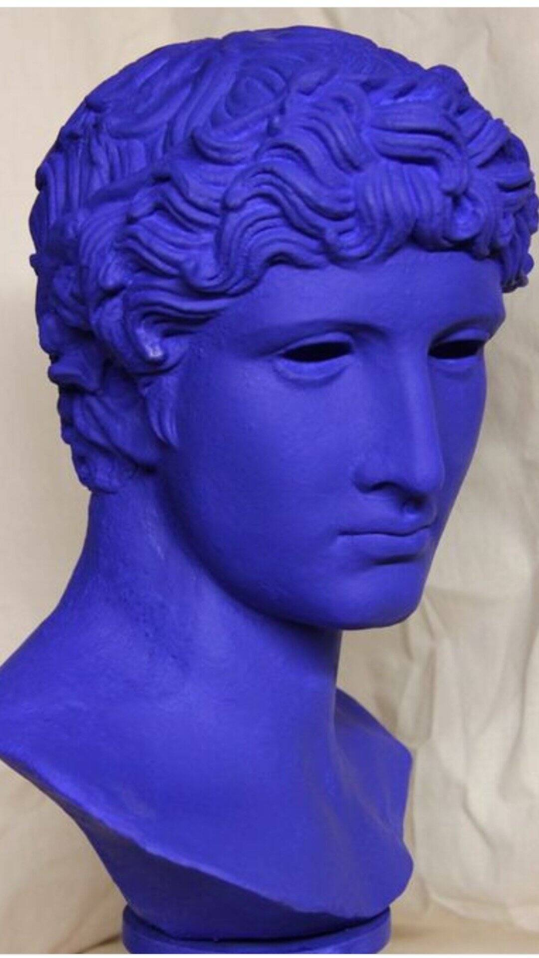 Large bust of a Greek Roman Apollo on a pedestal