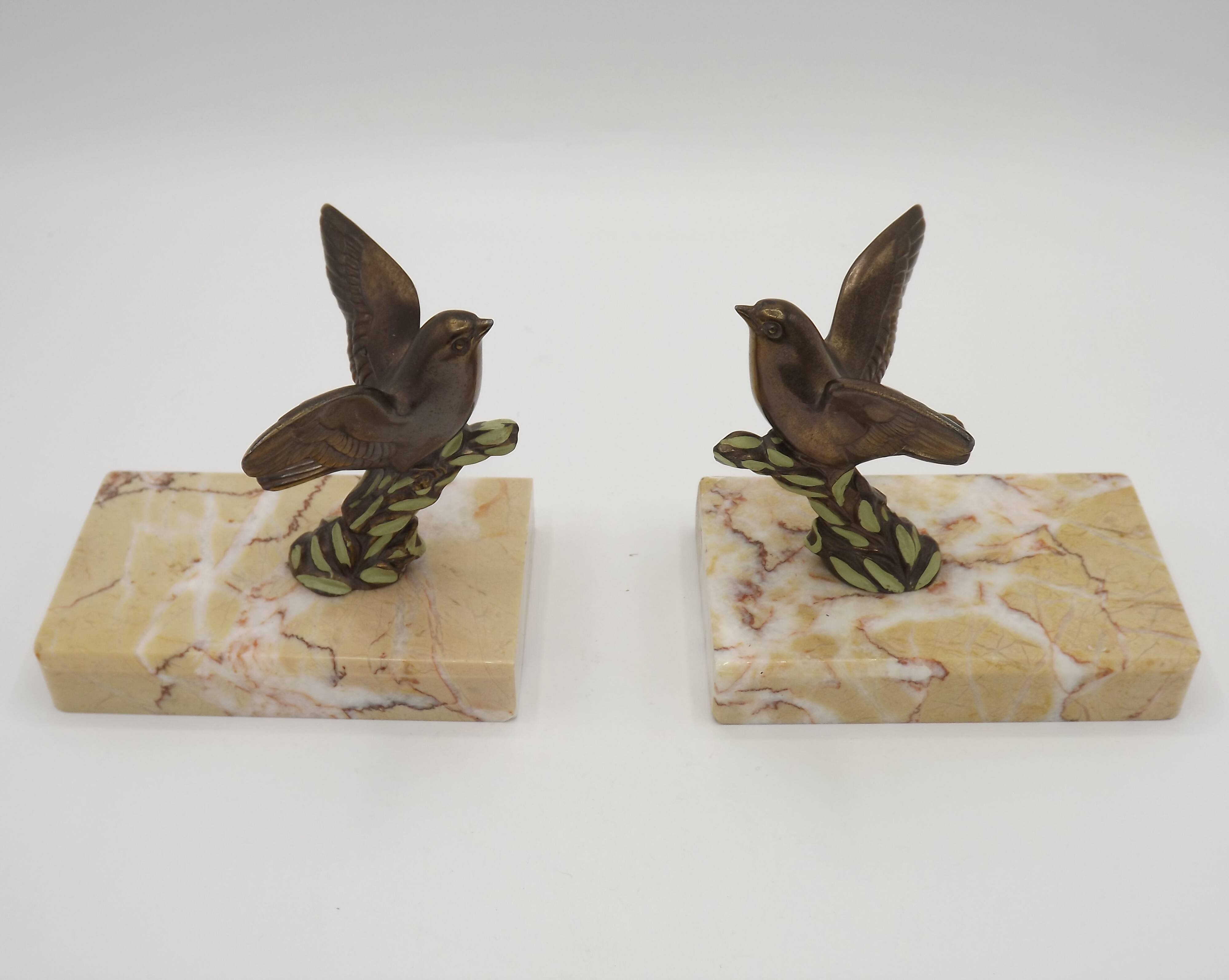 Paire de serre-livres Art déco français en étain représentant des oiseaux perchés sur une branche, socle en marbre