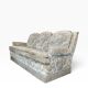 Vintage beige three-seater sofa with floral pattern and fringes.