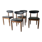 Quatre chaises de salle à manger Schreiber Mid Century en simili cuir noir avec dossier flottant.
