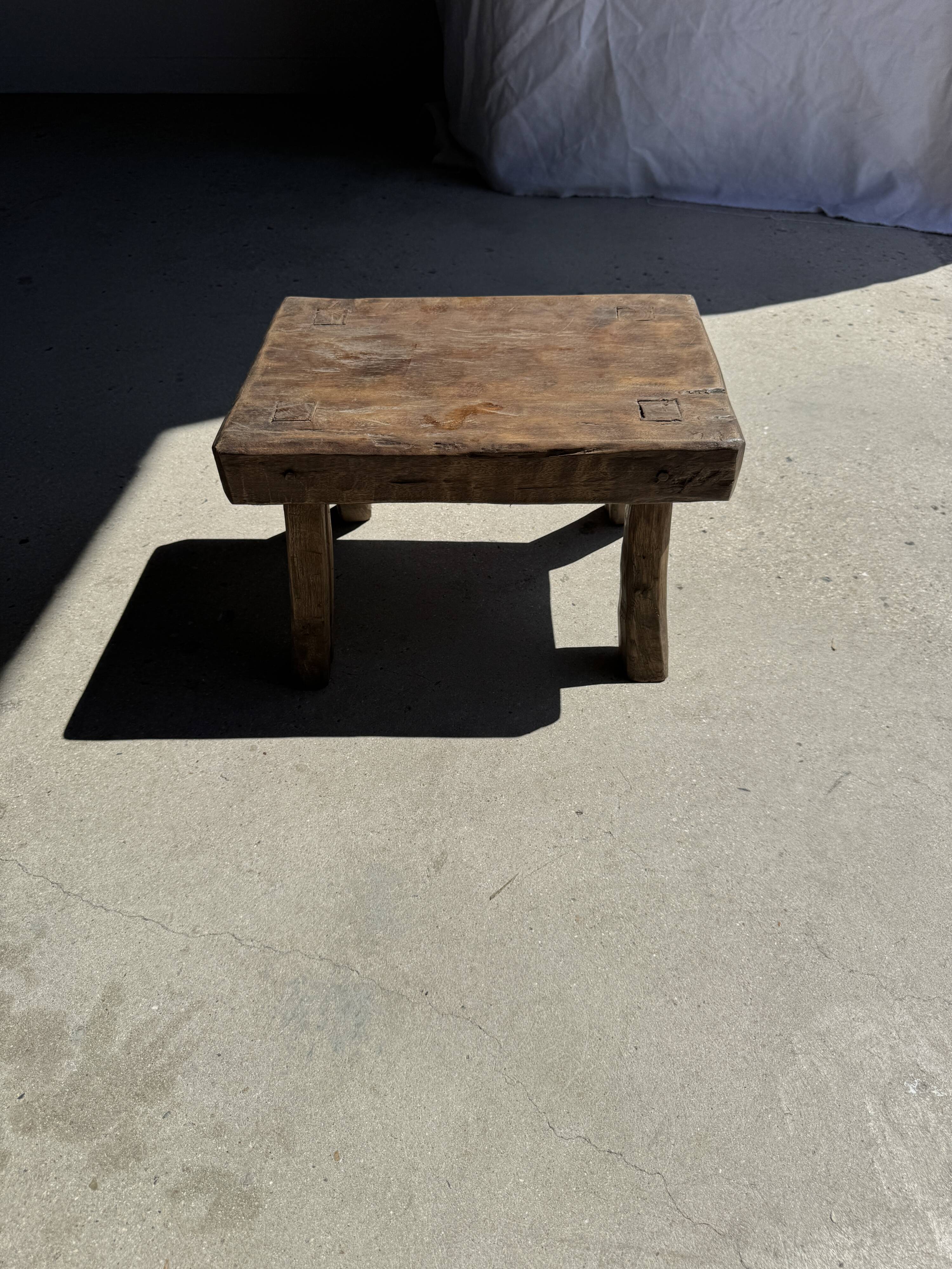 Small stool, rectangular solid teak side table with curved legs.