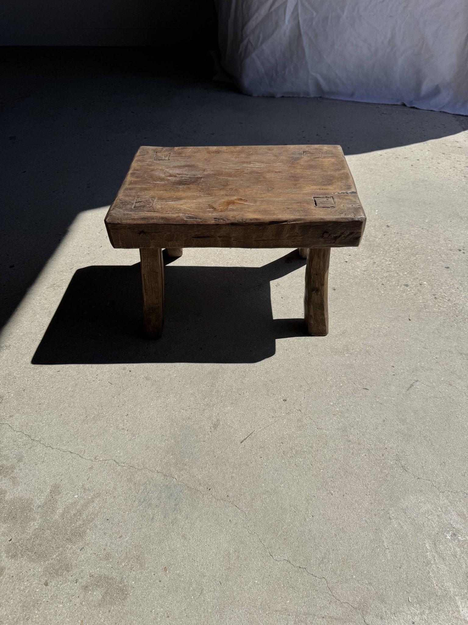 Small stool, rectangular solid teak side table with curved legs.