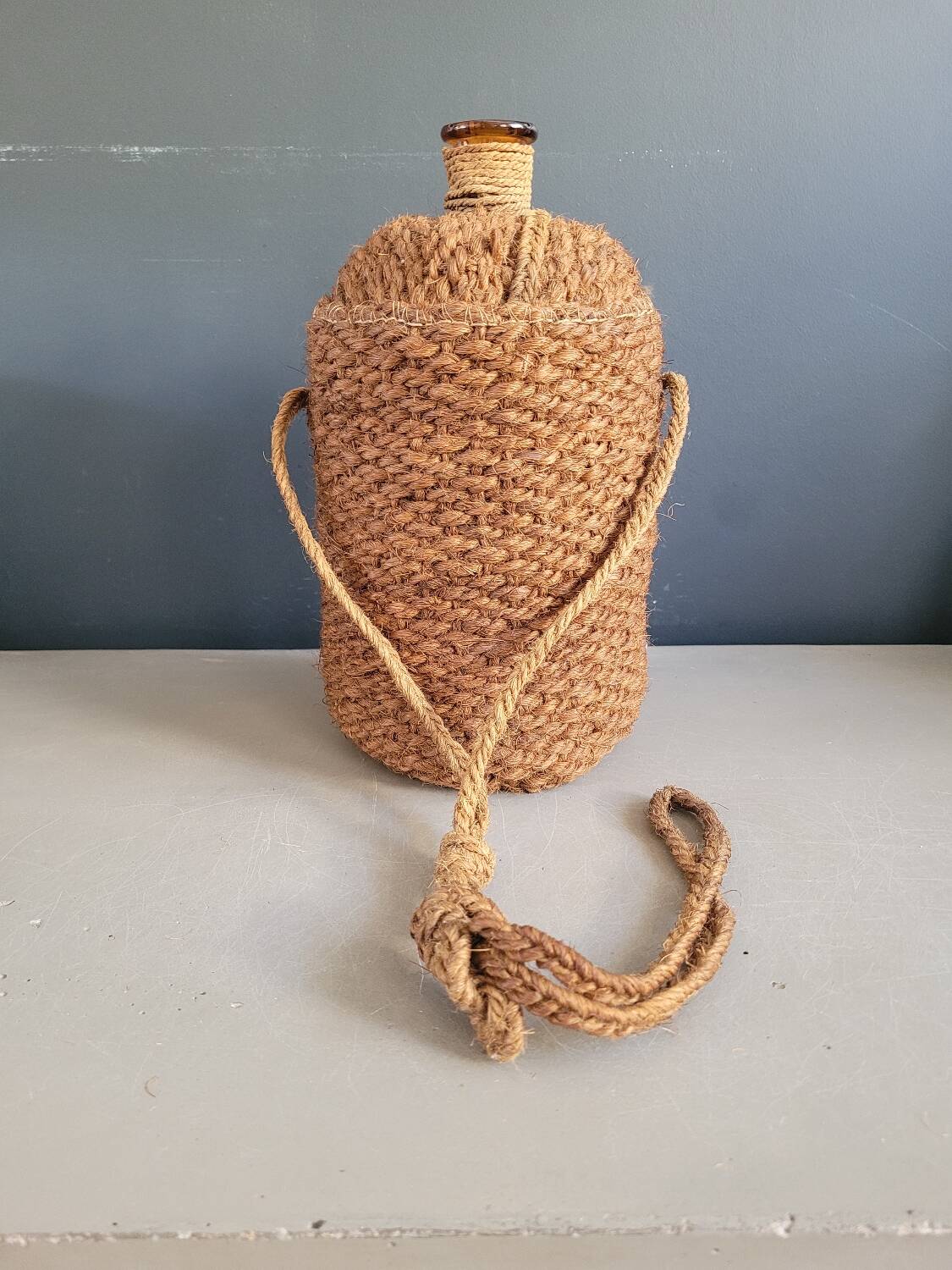 Antique amber glass bottle and hemp carrying bag