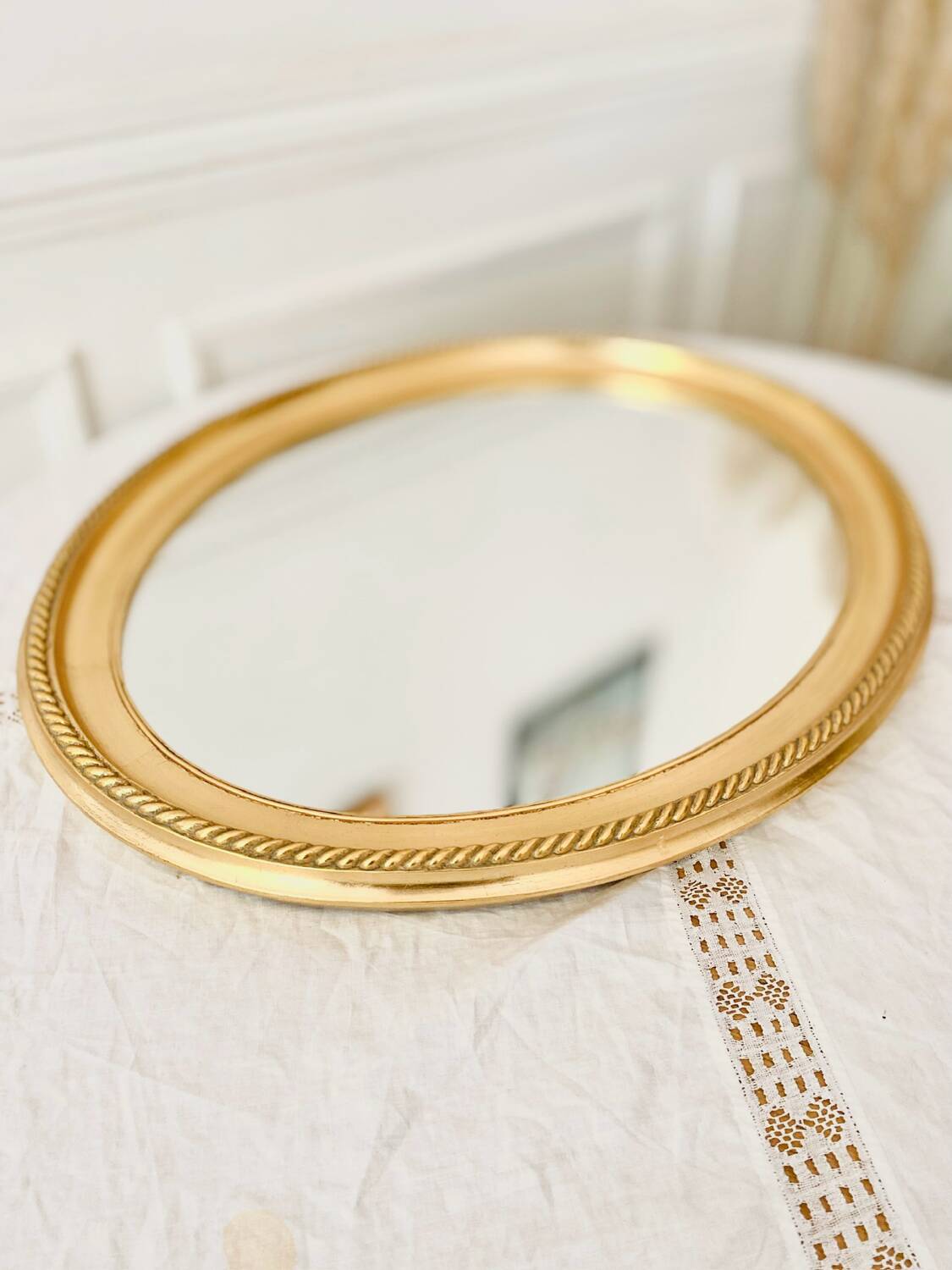 Oval wall mirror in gilded wood