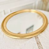 Oval wall mirror in gilded wood