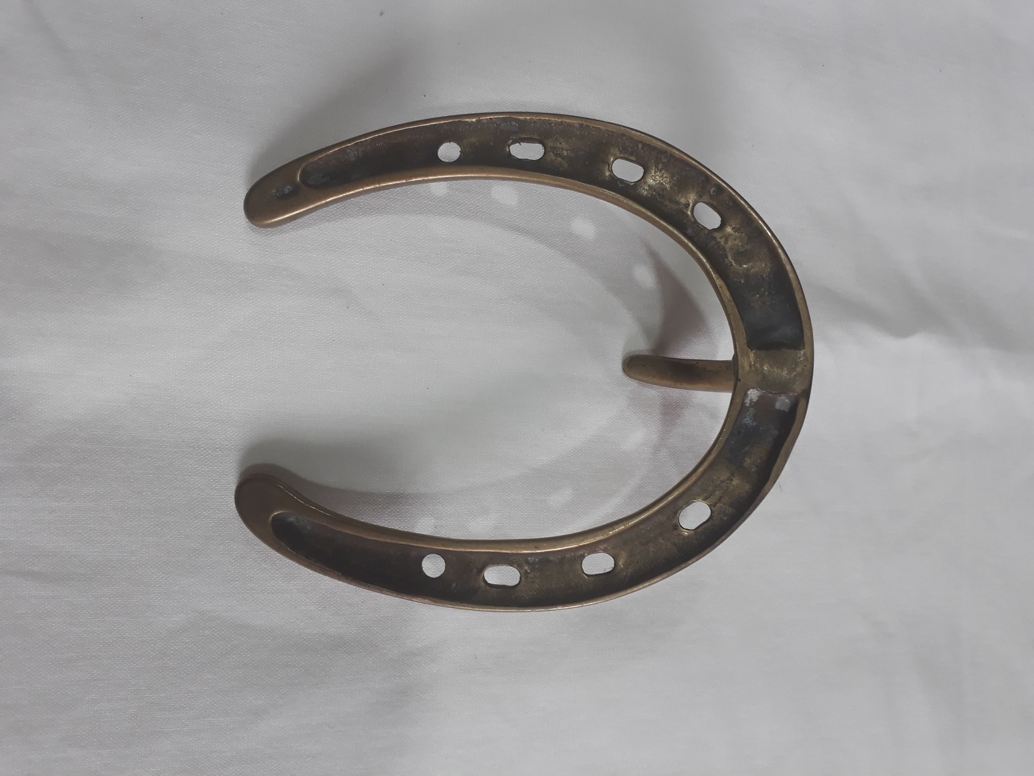 Horseshoe-shaped brass coat rack