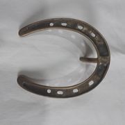 Horseshoe-shaped brass coat rack
