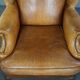 Old wingback armchair made of sheep leather in a correct condition