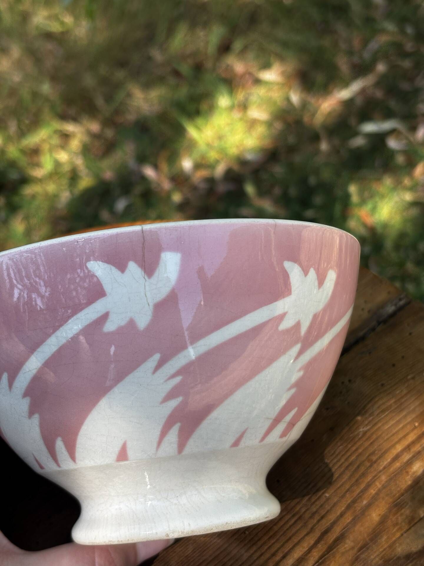 Old footed bowl in earthenware with pink decoration and defects.