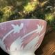 Old footed bowl in earthenware with pink decoration and defects.