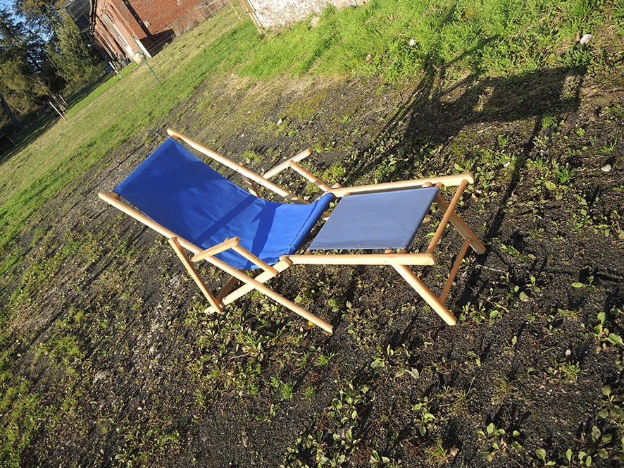 Old sunbathing in wooden & blue fabric