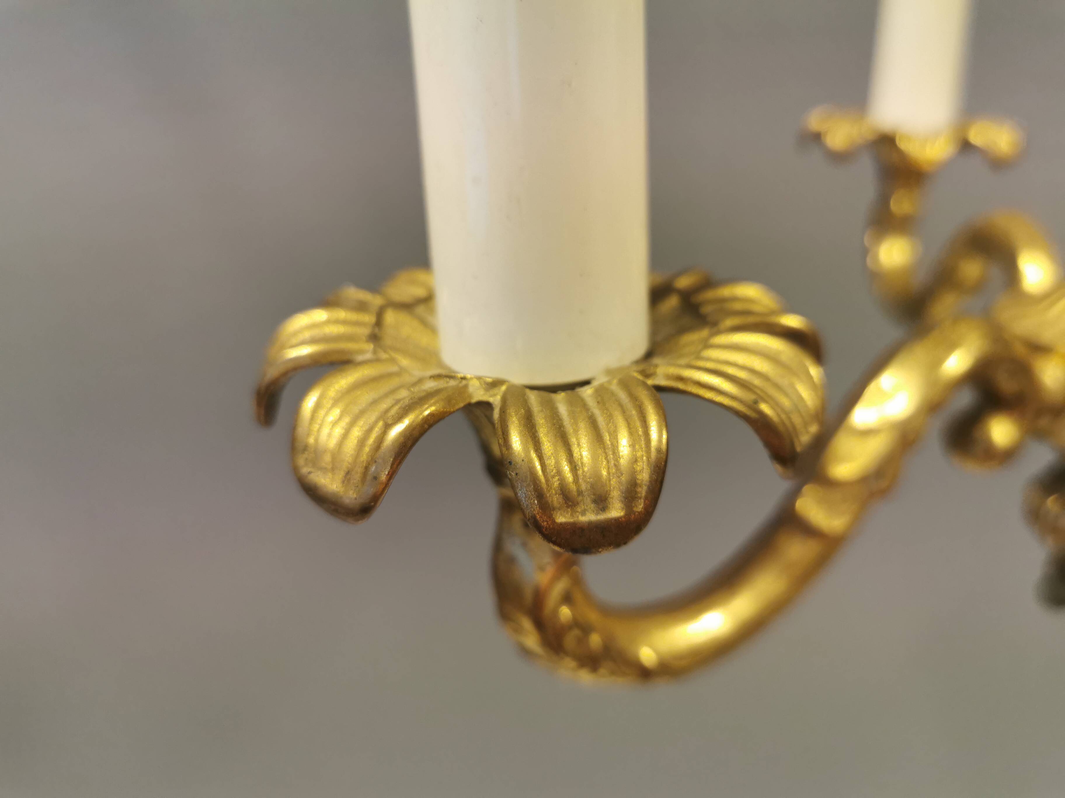 Older brass alloy chandelier with three light sources.