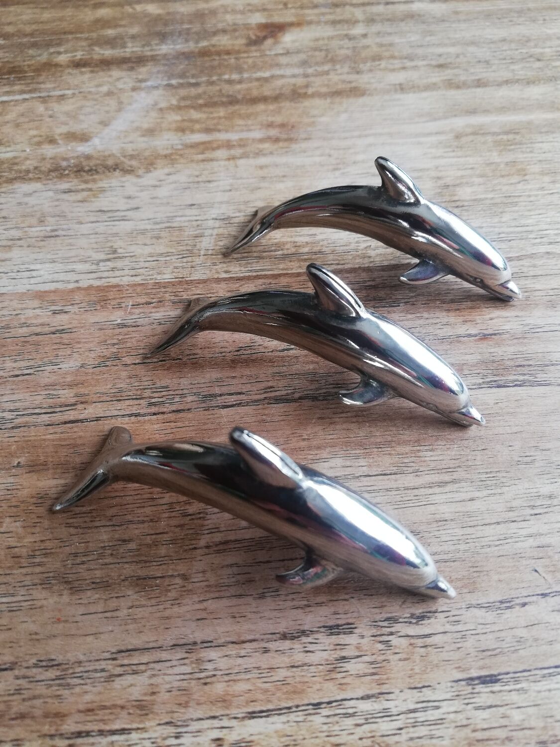 Set of three silver metal dolphin place markers
