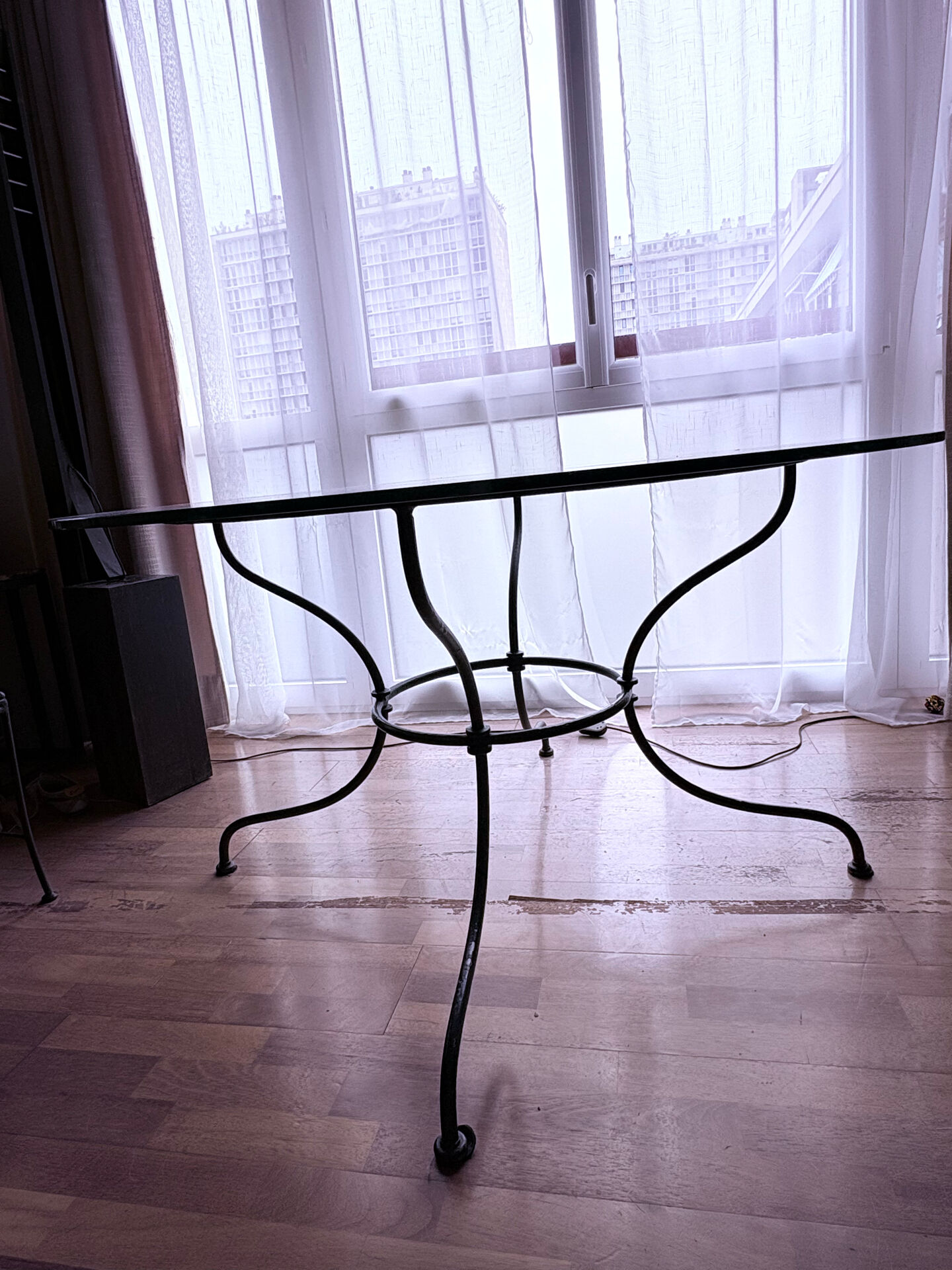 Round dining table in glass and wrought iron.