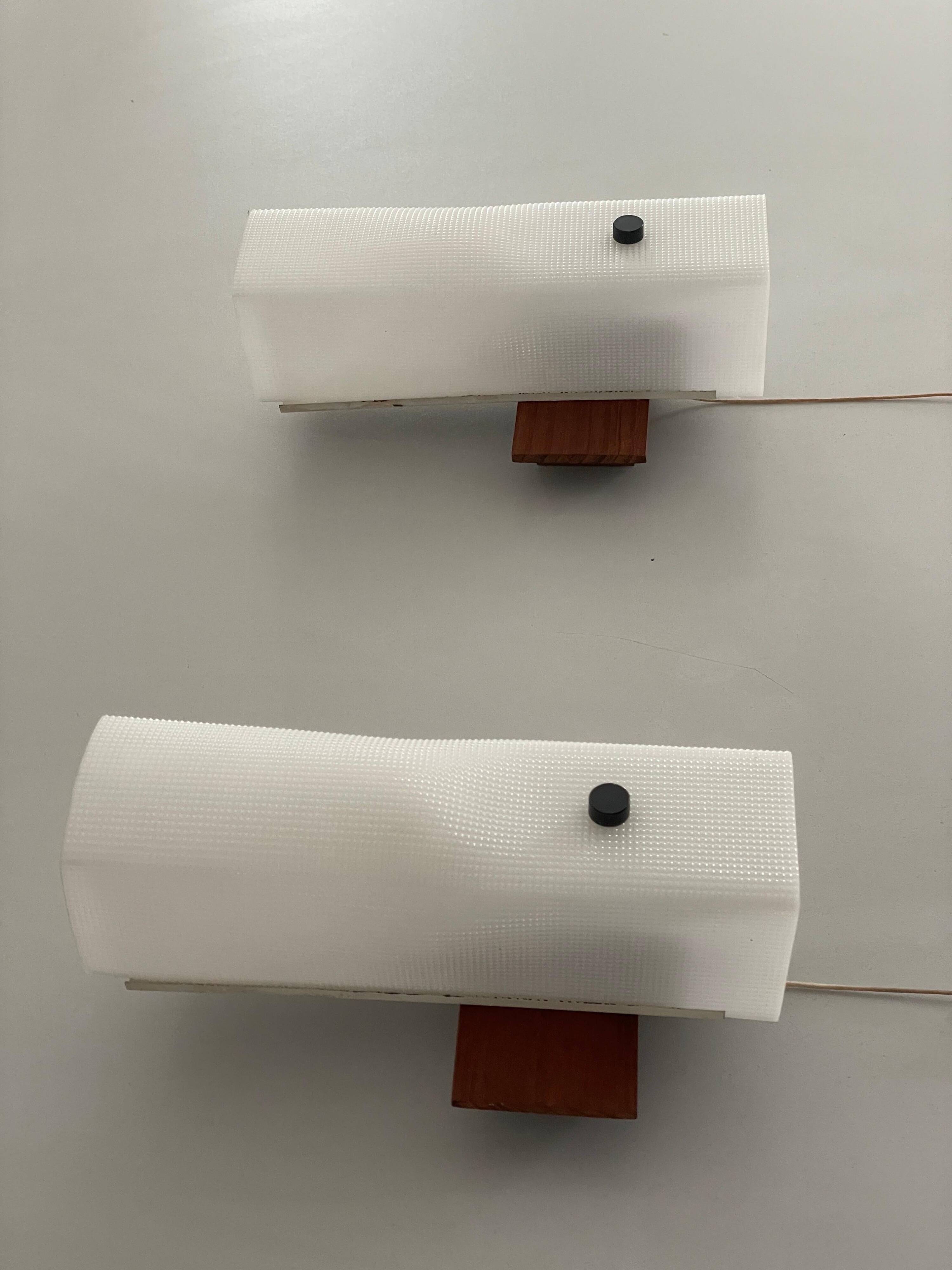 Mid-century wall lights in white plexiglass with a wooden base, 1960s, Germany.