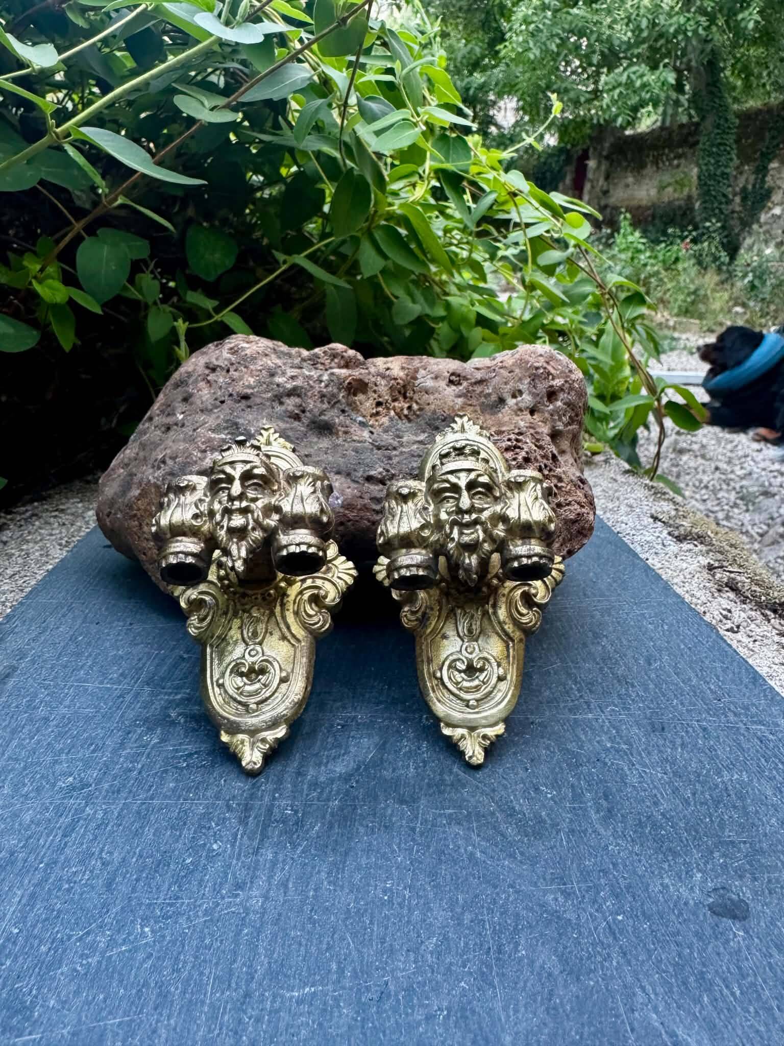 Pair of bronze wall sconces with mask, signed L. Pinet, Art Nouveau period.