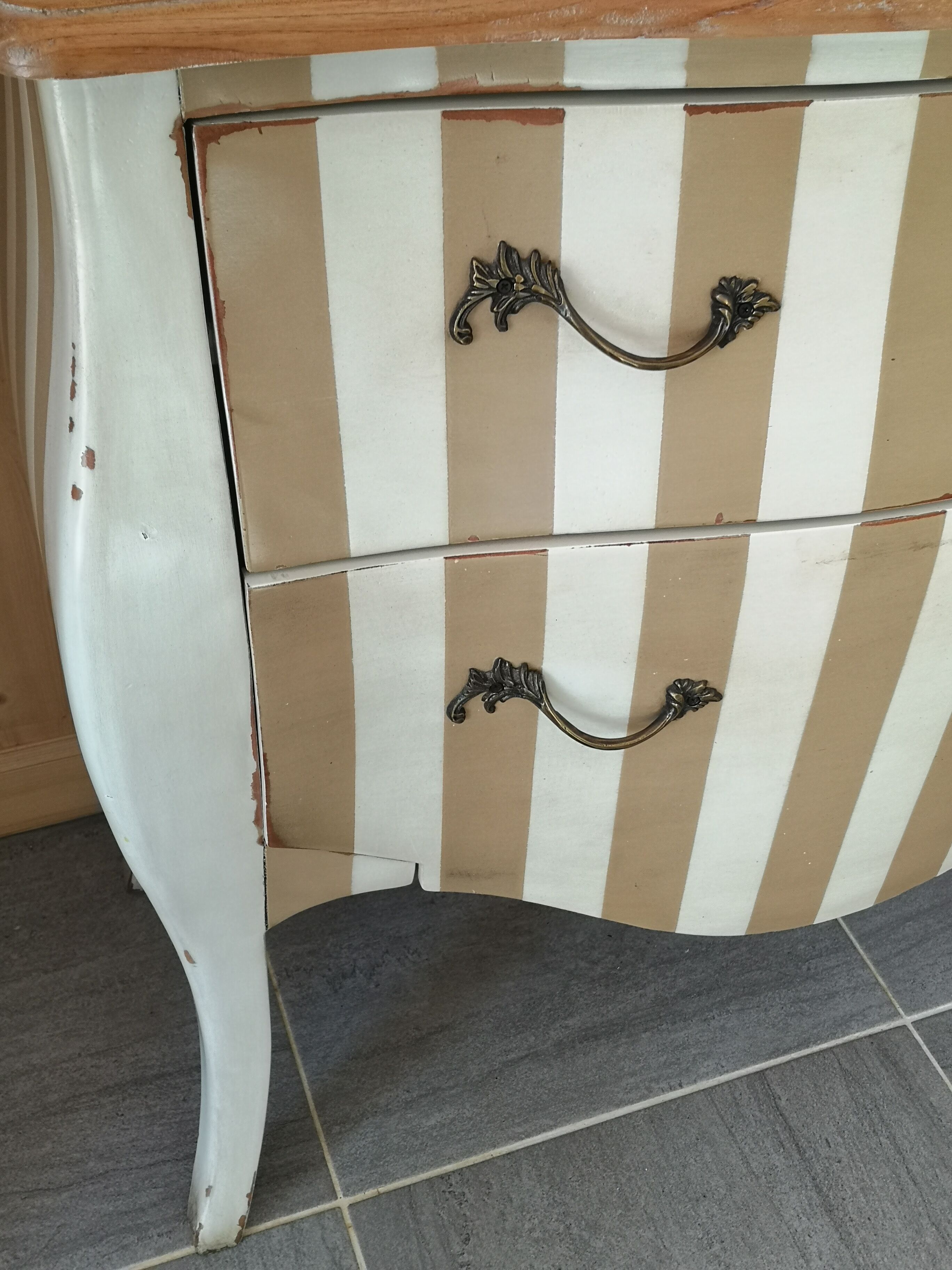 Curved commode with beige and white stripes.