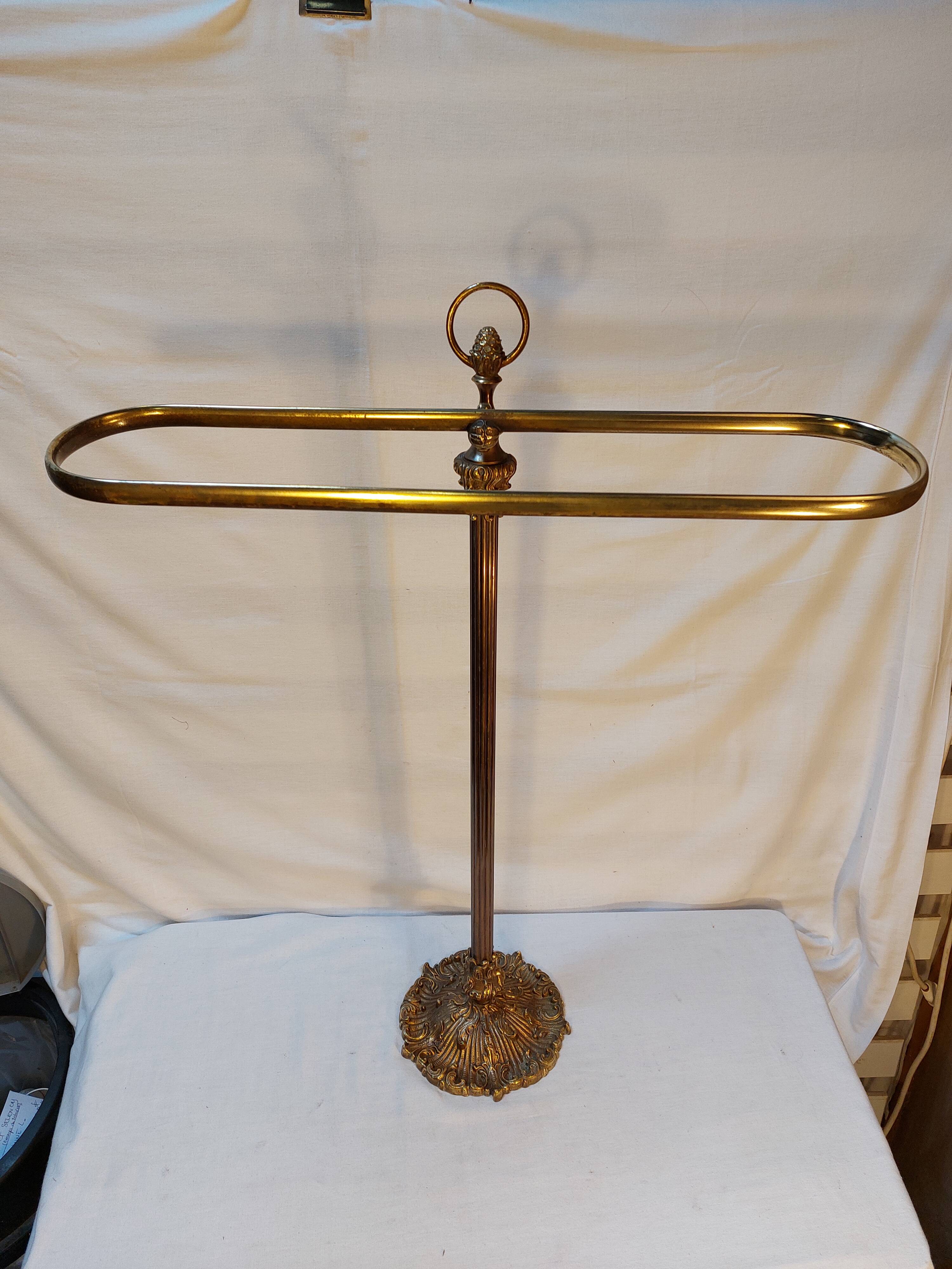 Old golden brass towel rack on baroque style foot