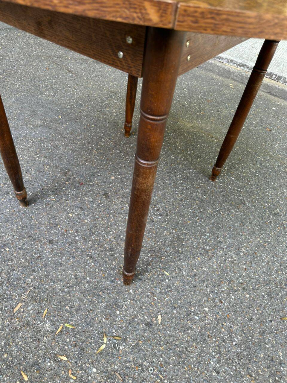 Round kitchen table with extendable leaves in dark wood.