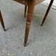 Round kitchen table with extendable leaves in dark wood.