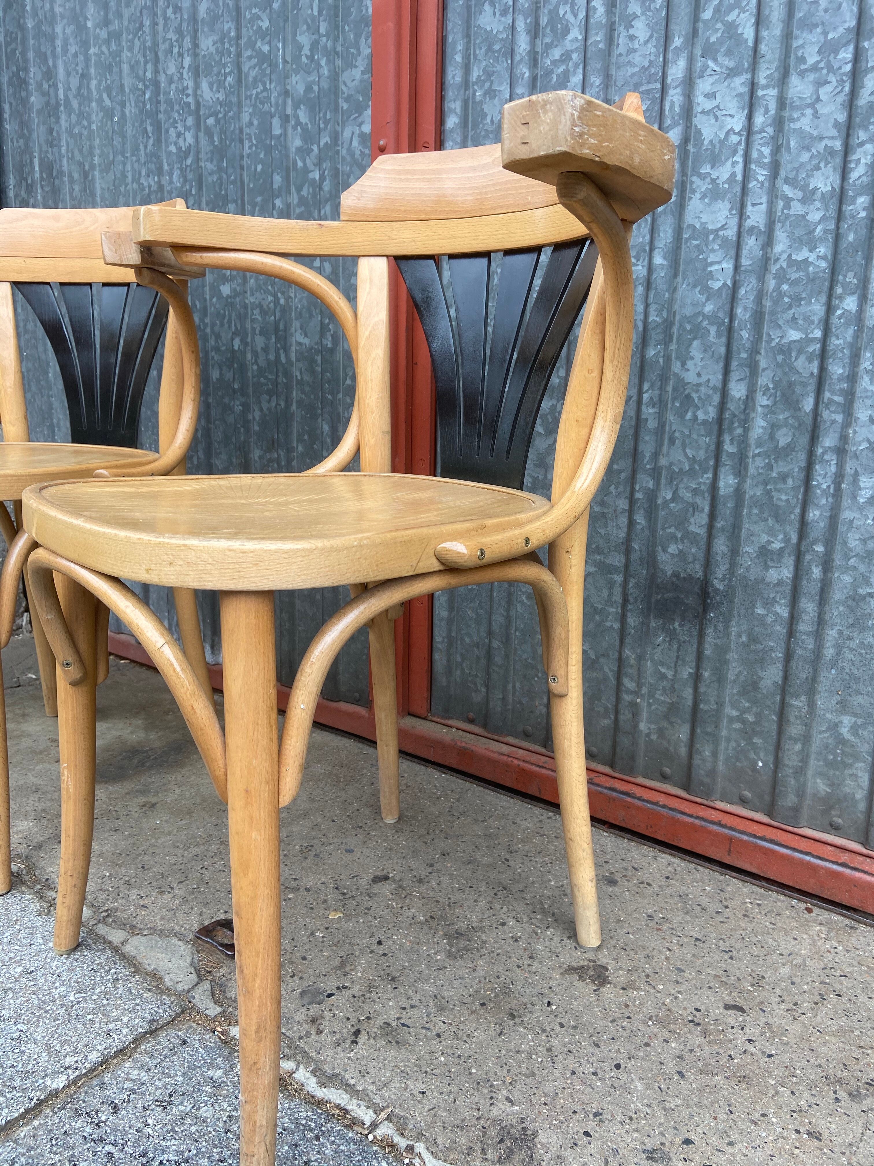 Pair of curved wooden bistro chairs with armrests