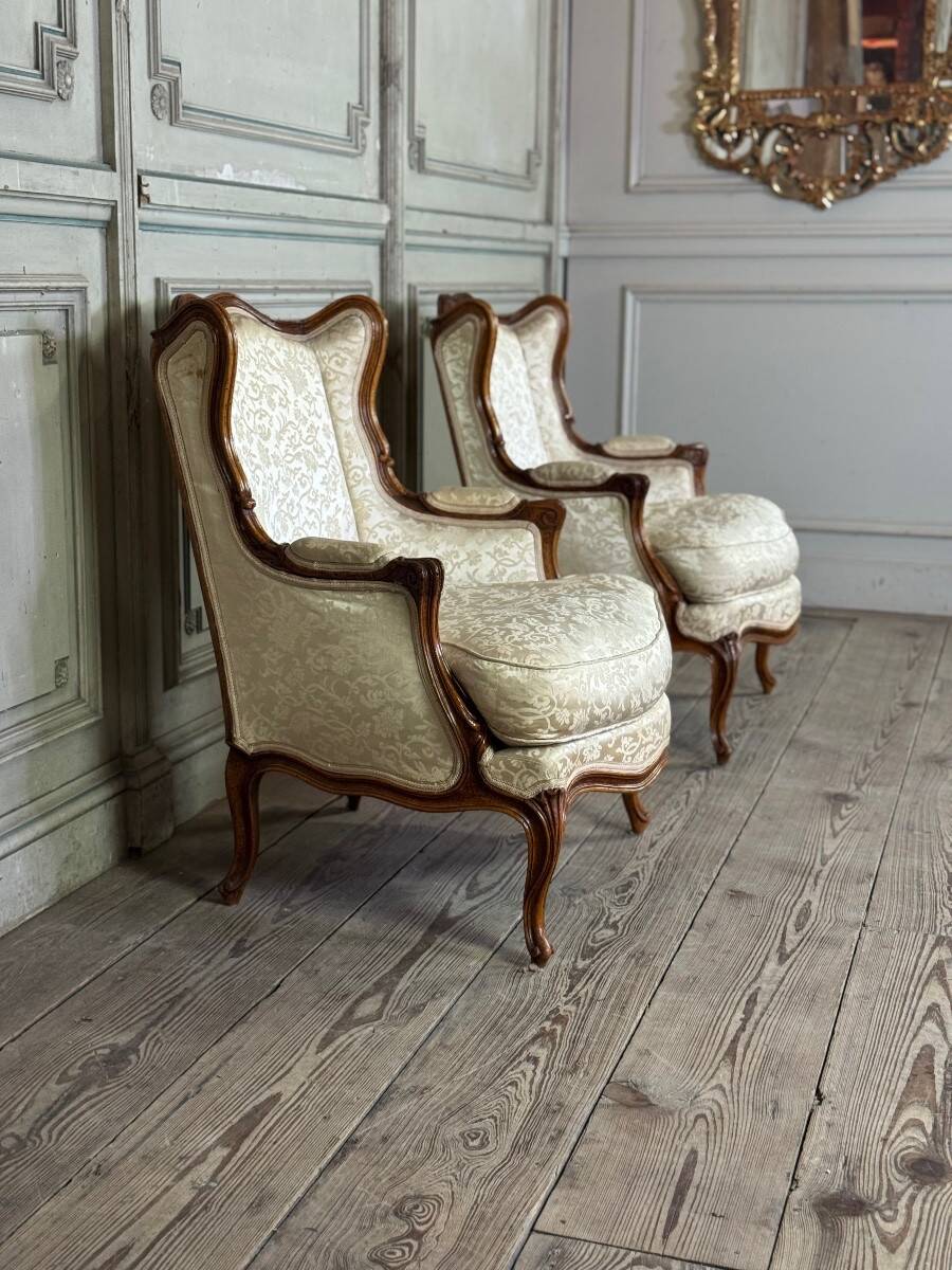 Pair of small Louis XV style wing chairs in carved walnut, Bosson stamp