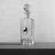 Vintage glass decanter from the 1980s, transparent glass with a silver plate and spherical stopper.