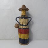 Old bottle dressed in scoubidou style rattan