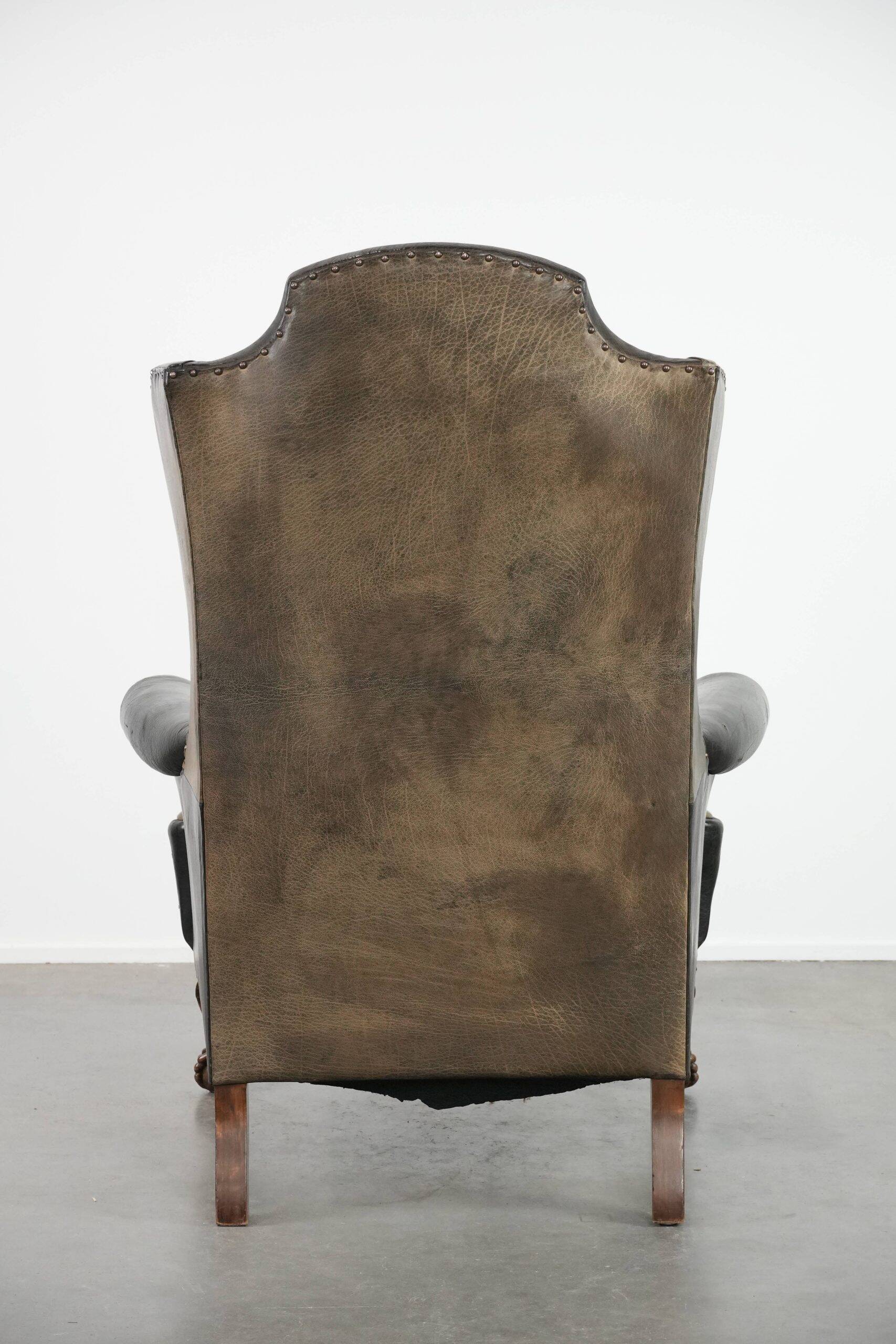 Antique black English cow leather wingback armchair from the 19th century