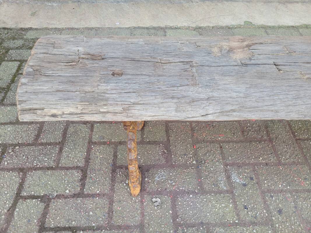 French country style cast iron bench with old rustic wooden plank