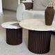Round nesting coffee table in travertine and dark fluted wood.