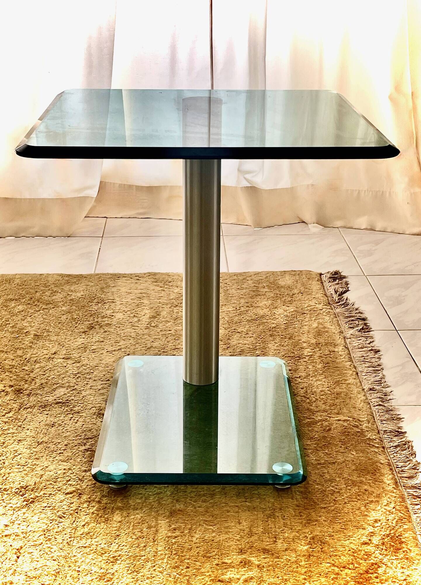 Contemporary square side table in glass with a metallic central column.