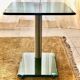 Contemporary square side table in glass with a metallic central column.