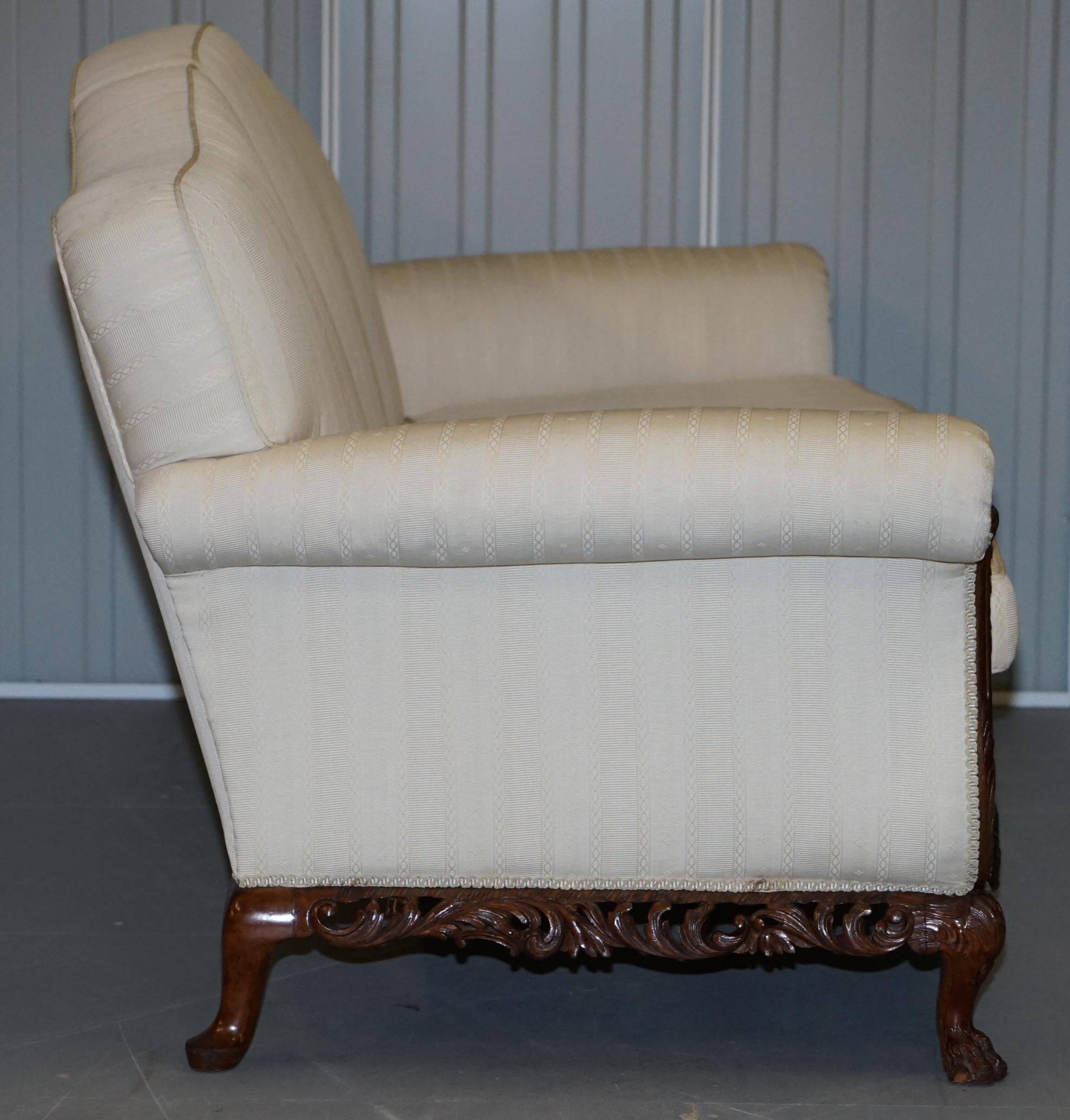 Three-seater canapé carved from solid walnut with claw feet.