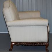 Three-seater canapé carved from solid walnut with claw feet.
