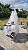 Old wooden rocking chair with turned legs and plumetis fabric.