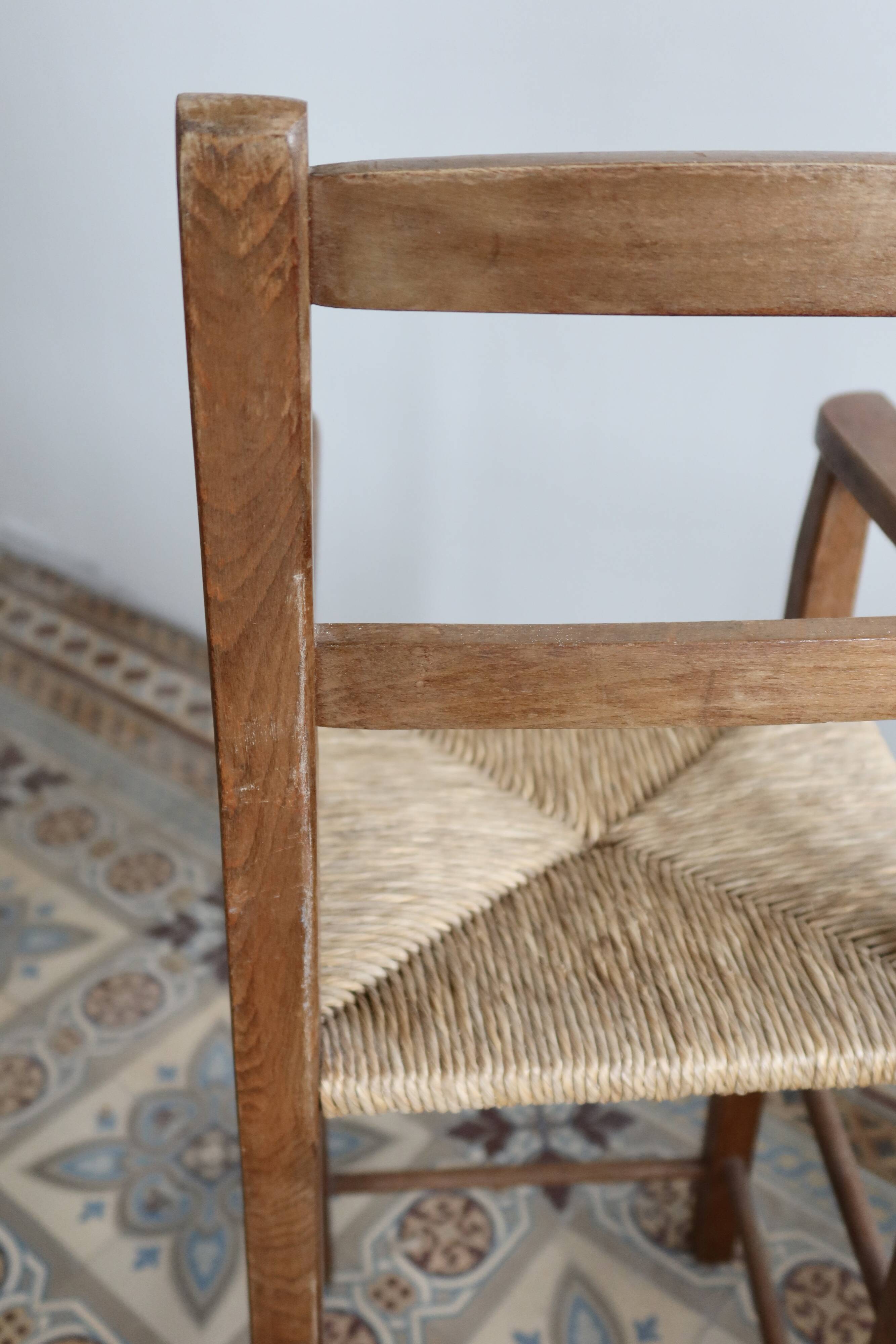 Vintage wooden high chair for children with a straw seat.