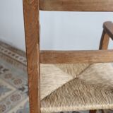 Vintage wooden high chair for children with a straw seat.