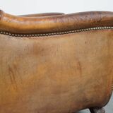 Characteristic antique sheepskin leather armchair with beautiful details and a unique design