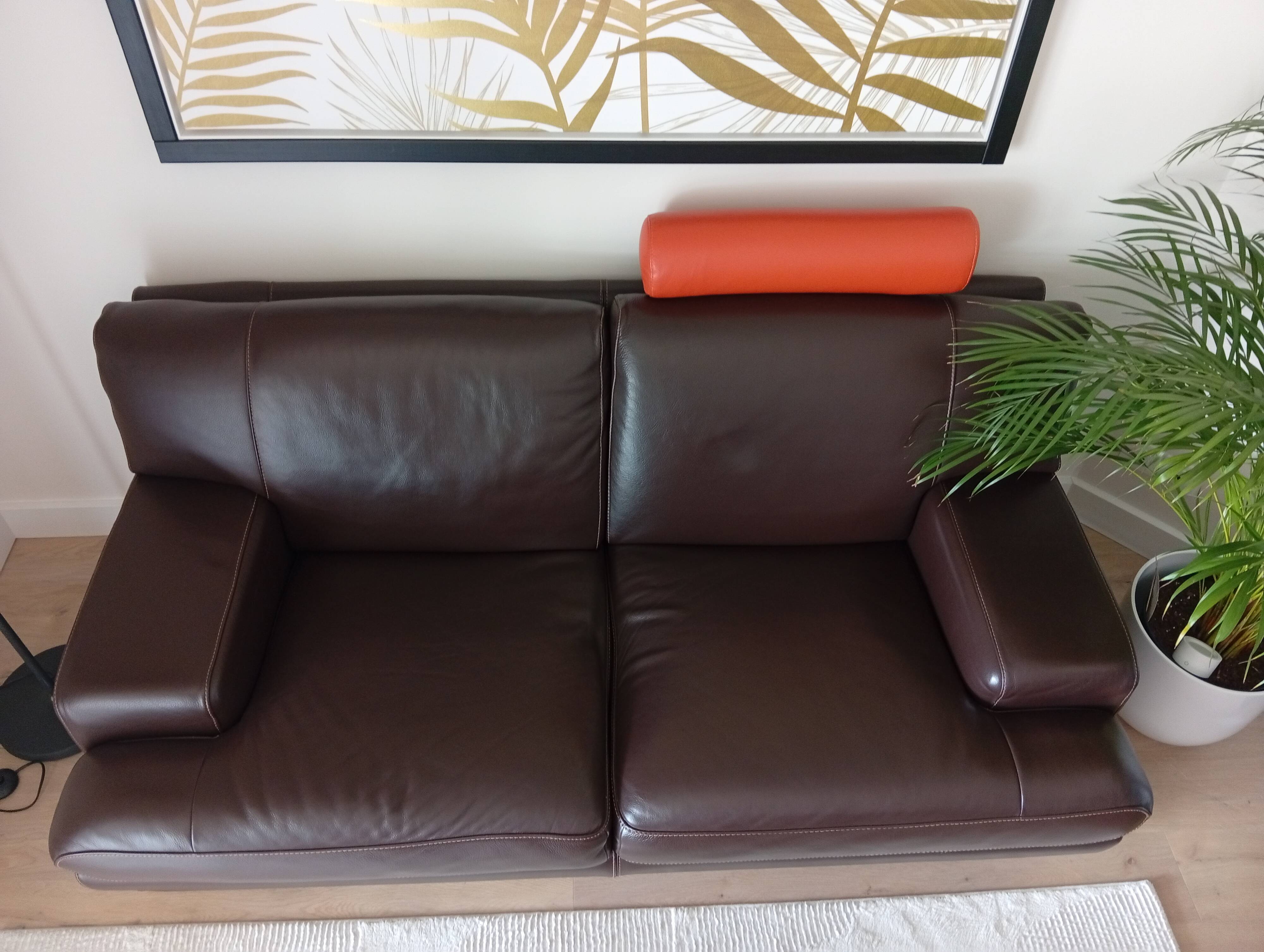 Two brown leather Crozatier two-and-a-half-seater sofas.