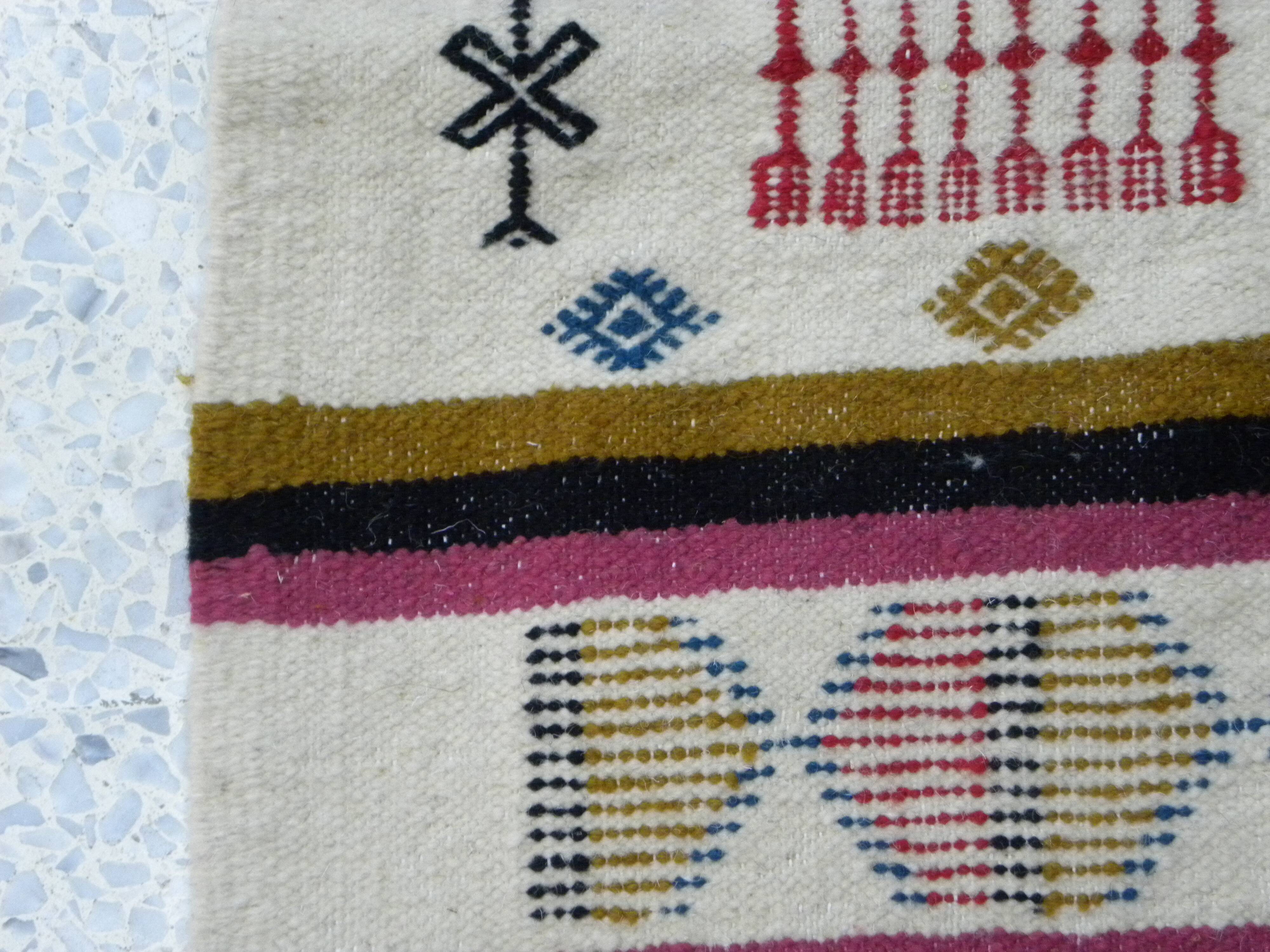 Handmade Berber kilim rug with multicoloured tribal motifs.