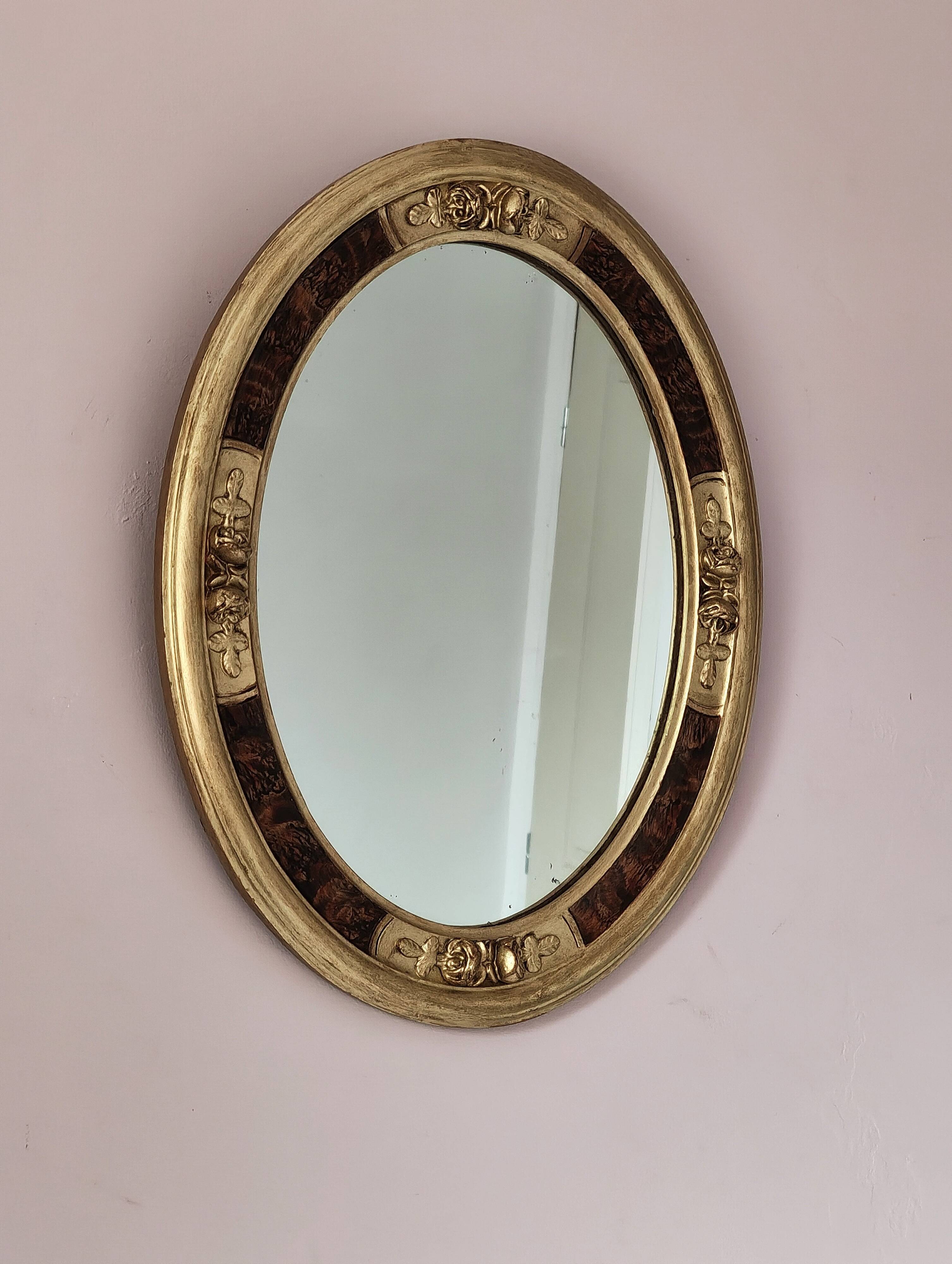 Antique medallion mirror with a gilded and relief-carved frame.