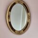 Antique medallion mirror with a gilded and relief-carved frame.