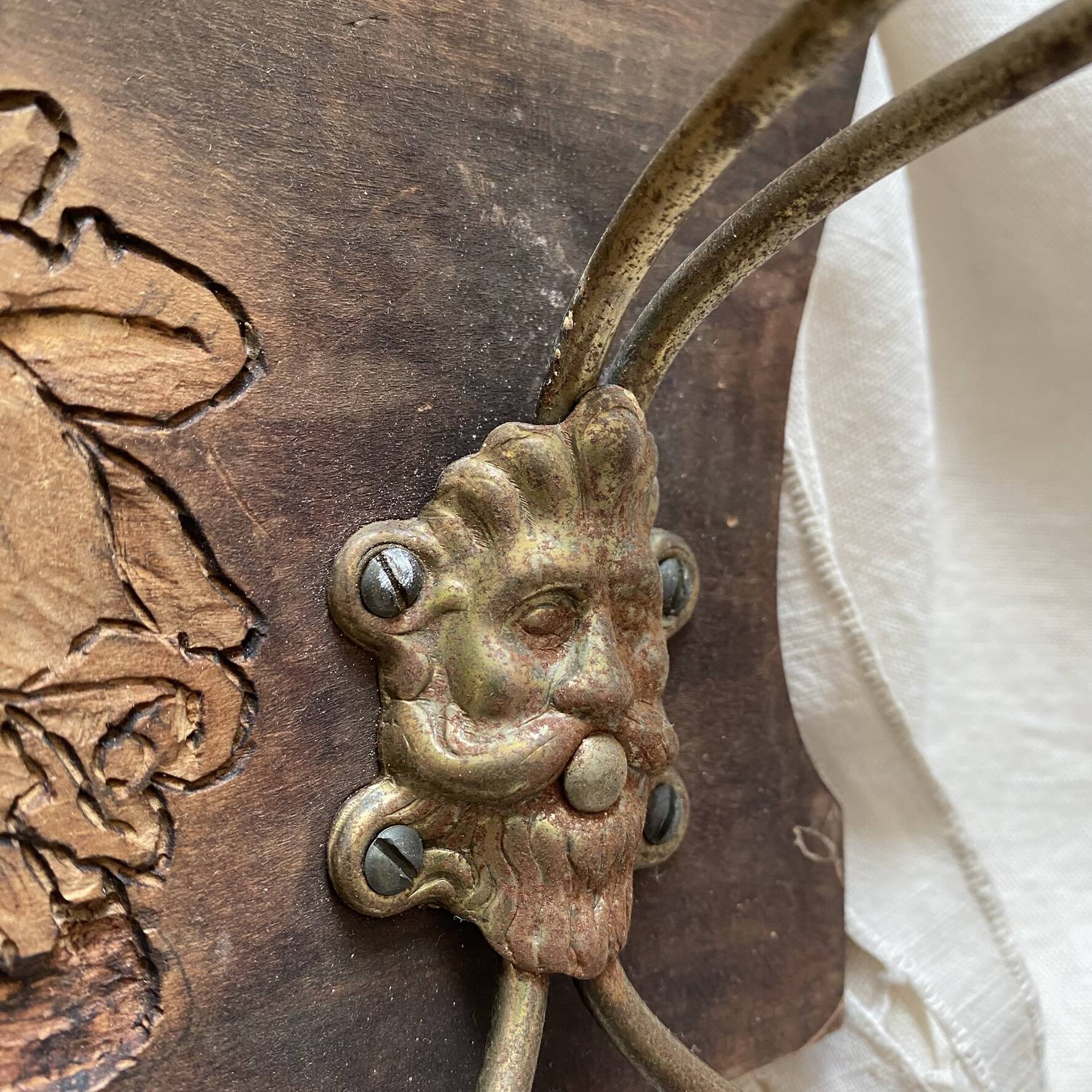 Wall-mounted coat rack in carved wood with rose decoration.