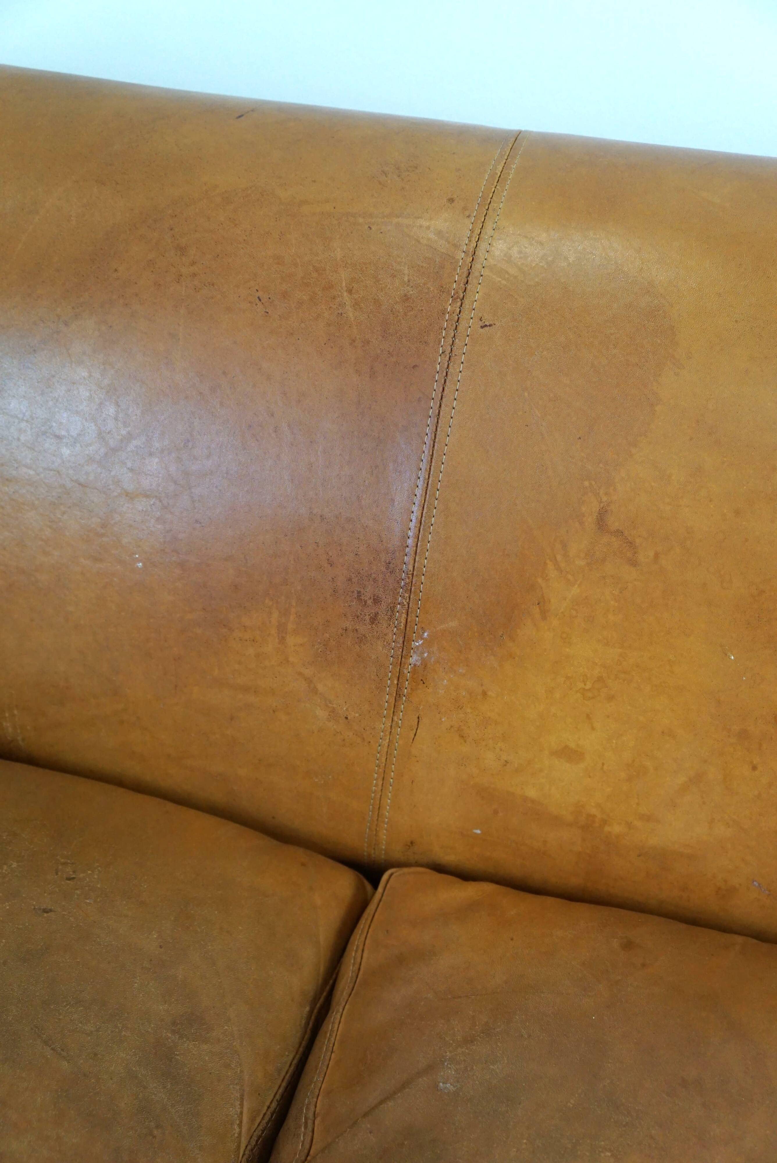 Unique old set of 2 club armchairs and a couch in cognac-colored leather with wheels